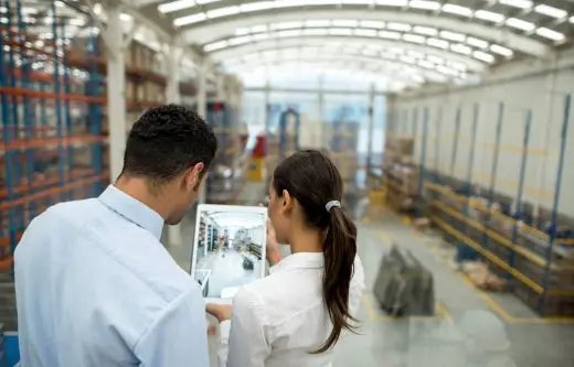 Business couple working on freight transportation Business couple working on freight transportation and using a tablet computer to check stock at a warehouse